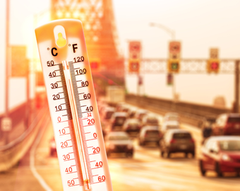 picture is of a road on a summer day with the image of a thermometer