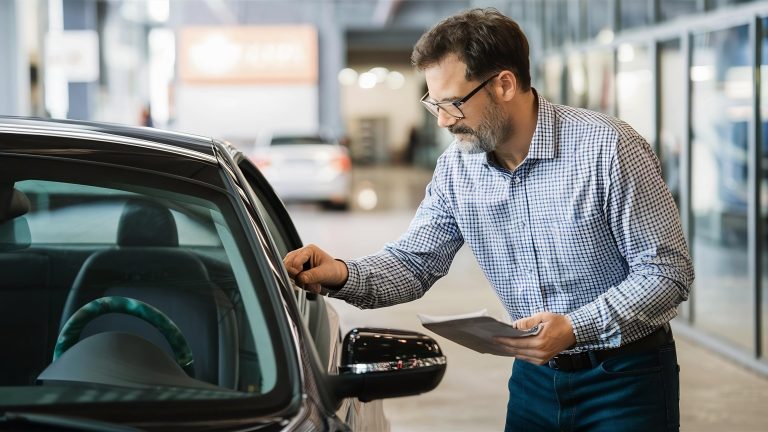 A man inspecting a vehicle to ensure that it is in good working condition.